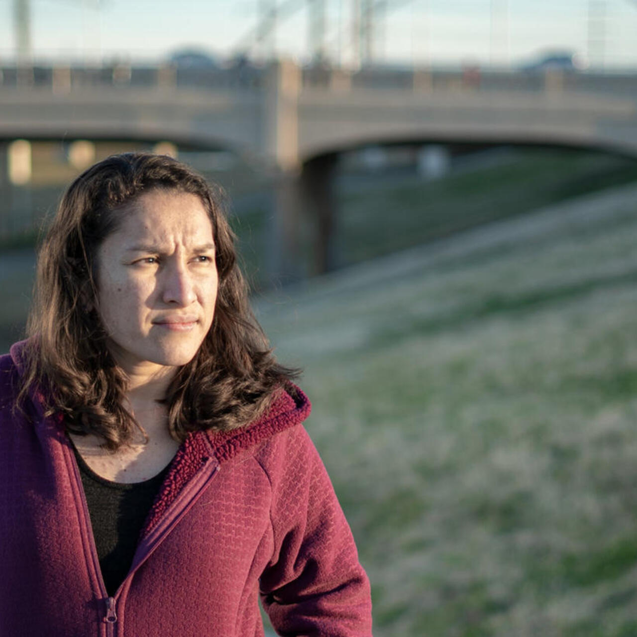 Valentina blickt in die Ferne.Hinter ihr ist eine Brücke zu sehen.
